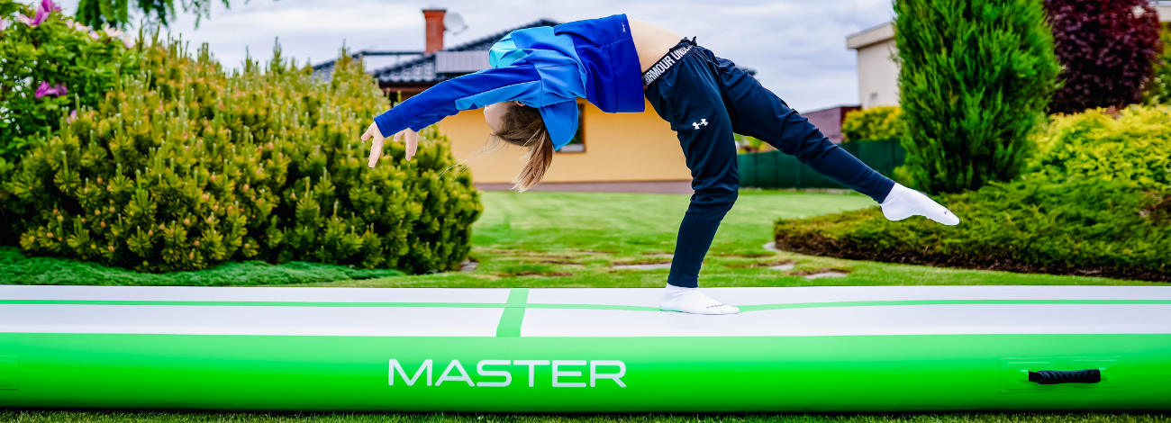 Deti skákajúce na nafukovacom airtracku na záhrade